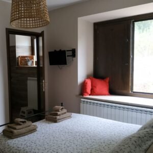 Hotel room with a big window and television on wall